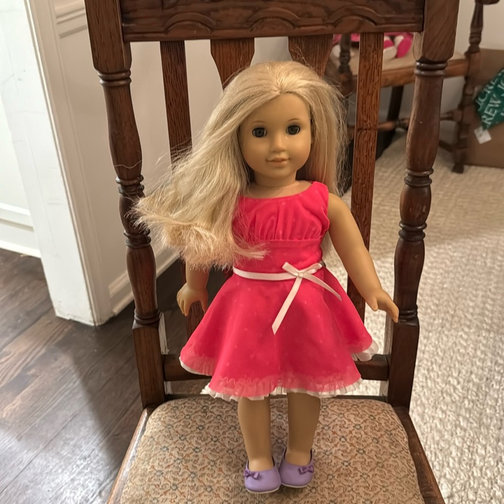 American Girl Doll. Blonde hair. Brown eyes. Pink dress and shoes included.